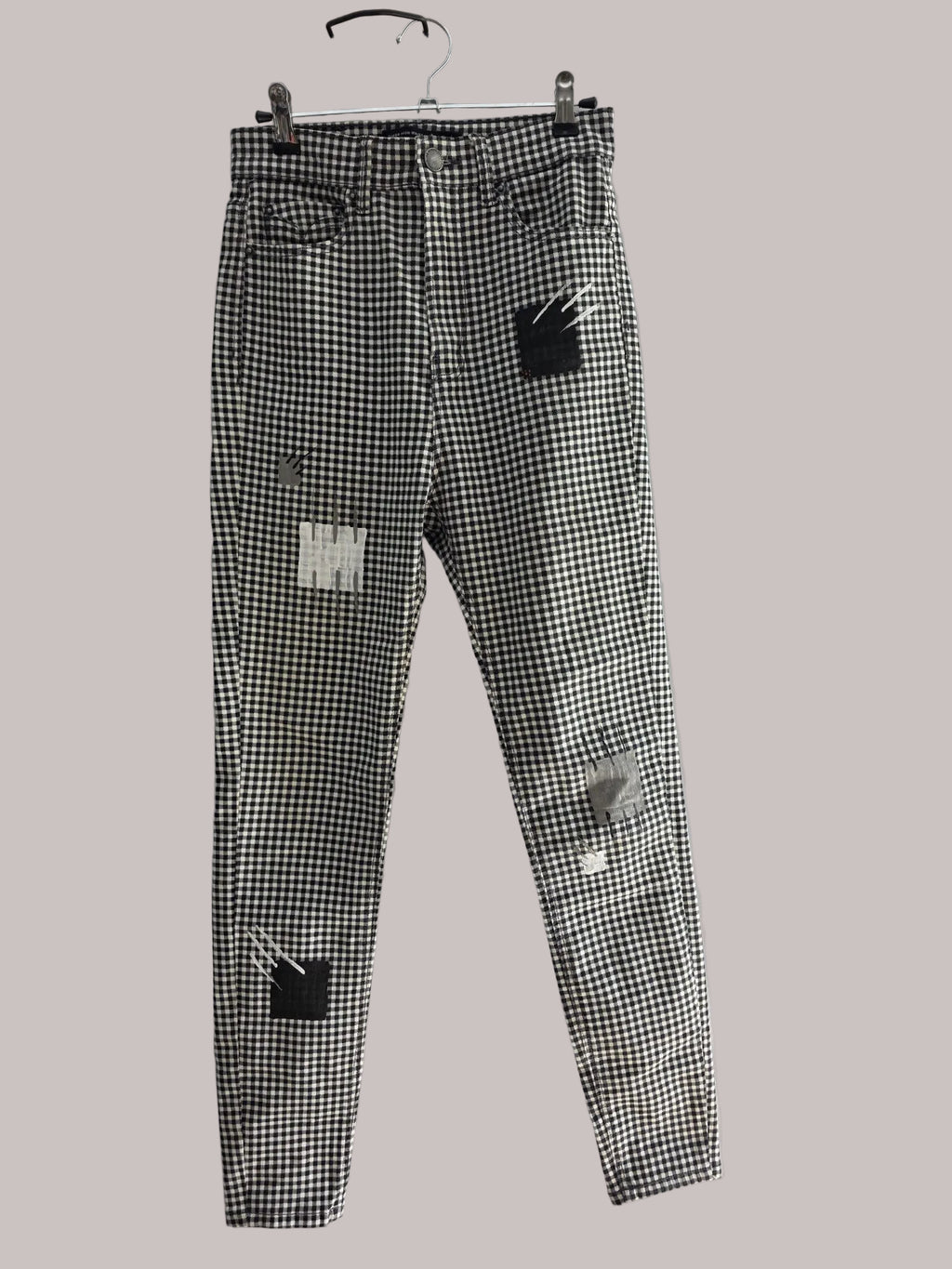 Vista frontal completa de un pantalón Stradivarius de cuadros blancos y negros con detalles artísticos pintados a mano