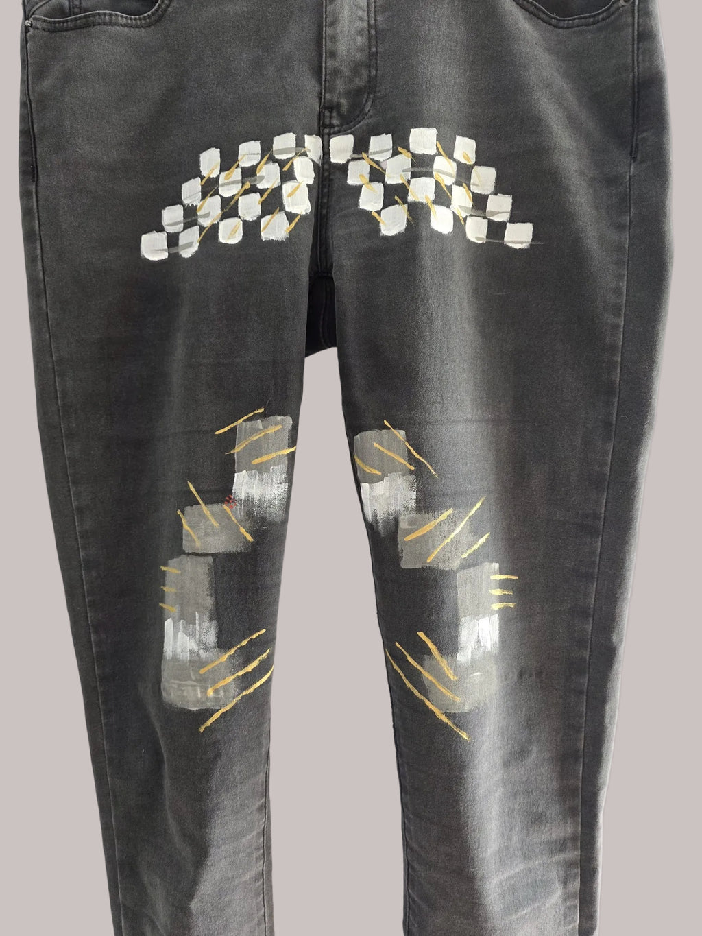Detalle de la intervención artesanal en el pantalón de denim gris oscuro