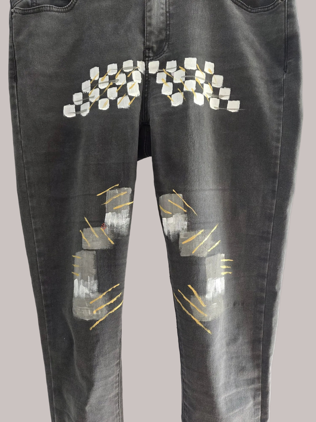 Detalle de la intervención artesanal en el pantalón de denim gris oscuro