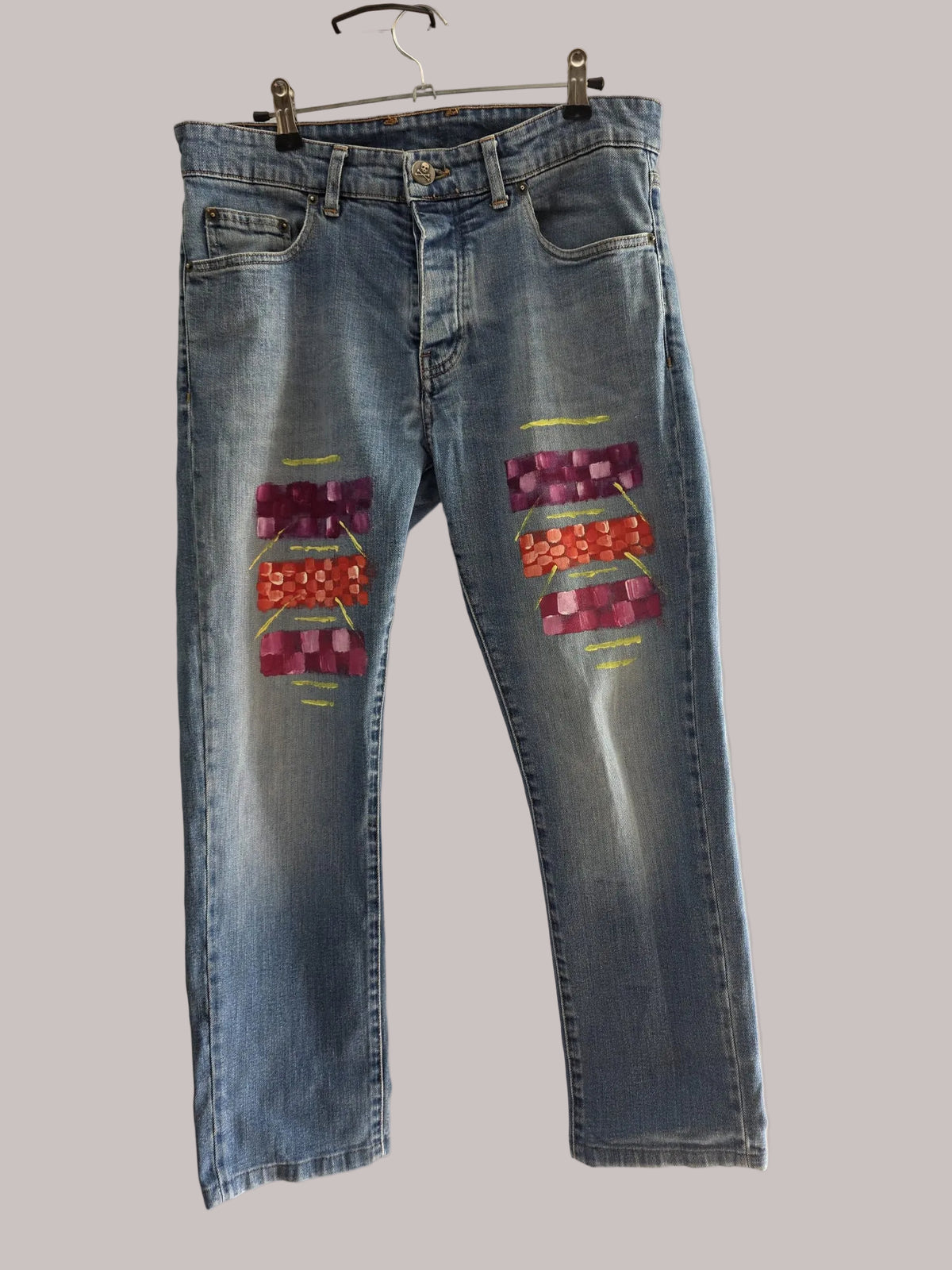 Vista frontal de vaquero Scalpers azul con bloques geométricos fucsia, coral y trazos dorados pintados a mano
