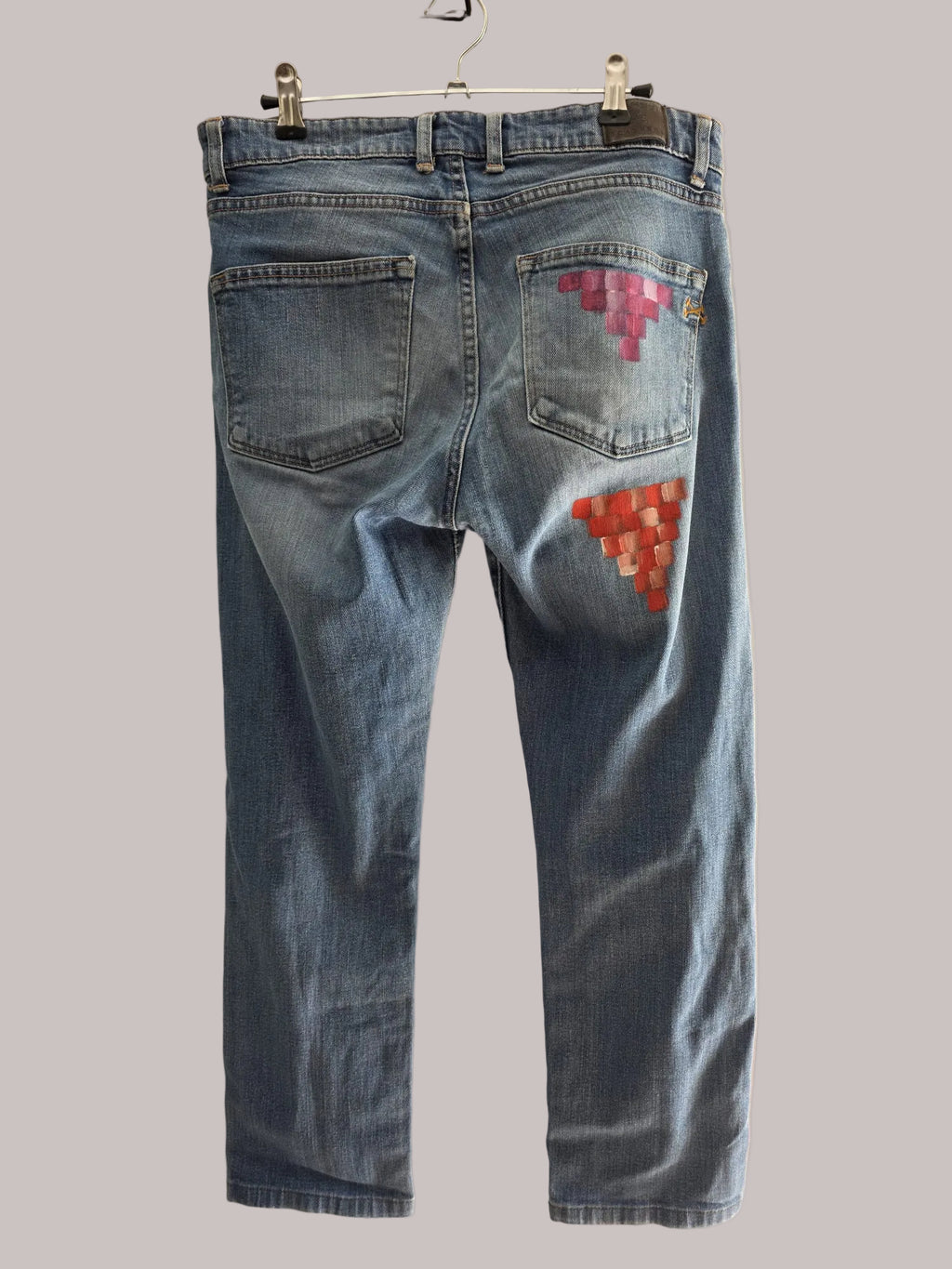 Detalle de bloques fucsia y rosa pintados sobre un bolsillo vaquero