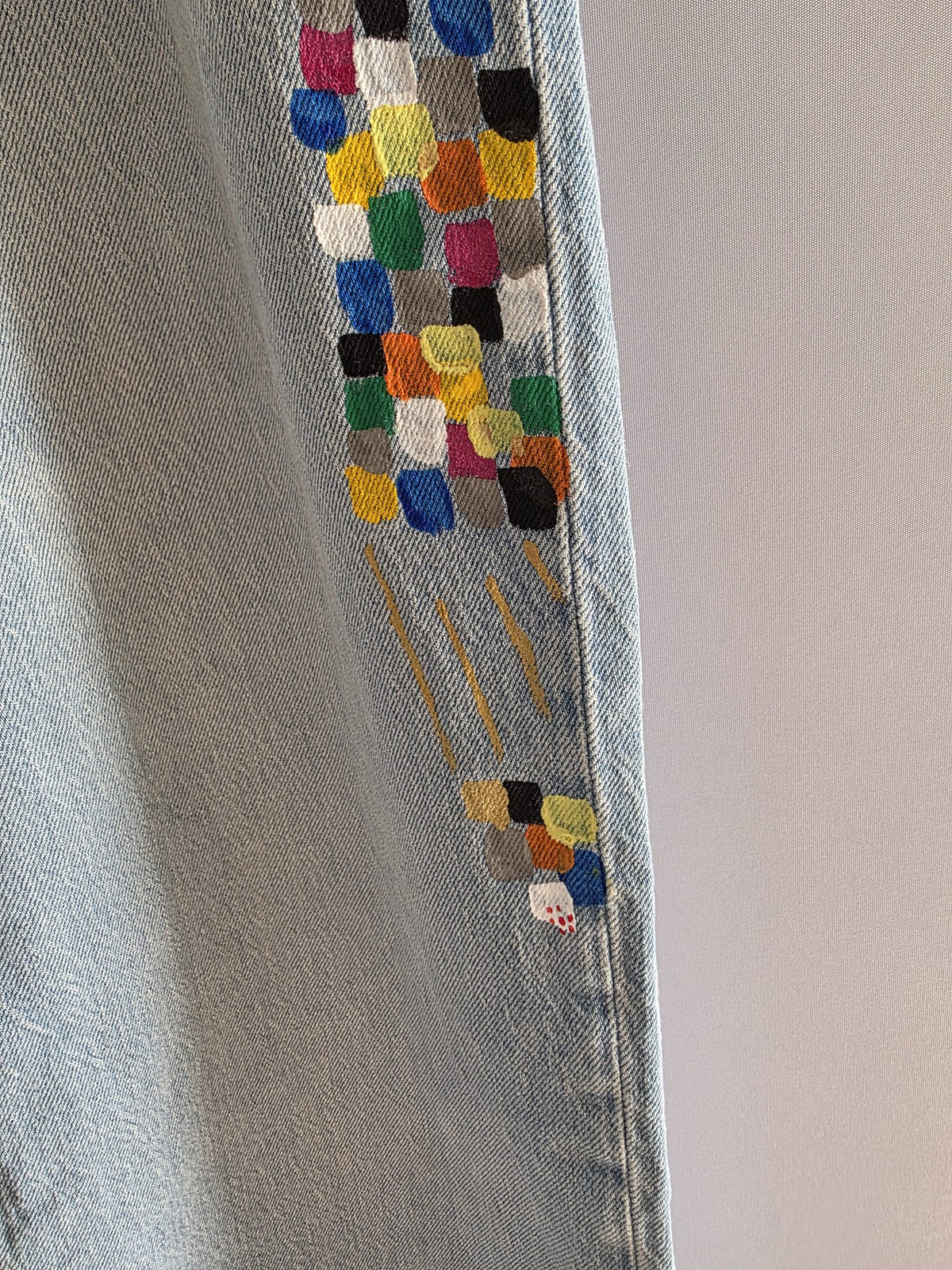 Vista frontal completa de vaquero MNG claro con bandas geométricas multicolor pintadas a mano