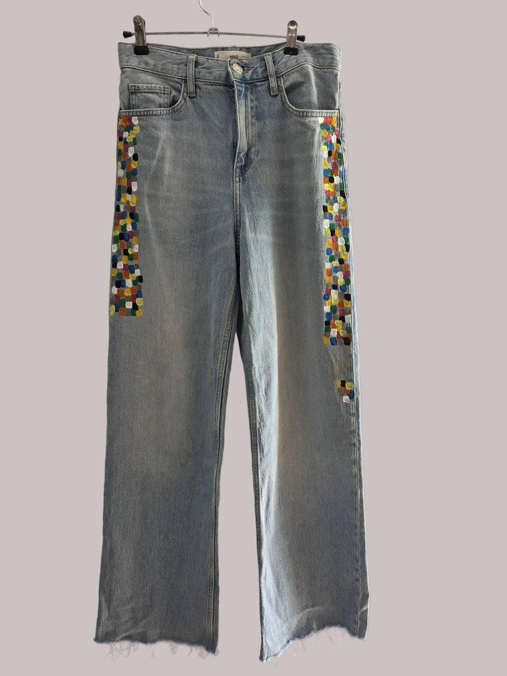 Detalle de bloques geométricos de varios colores pintados a mano sobre el denim claro