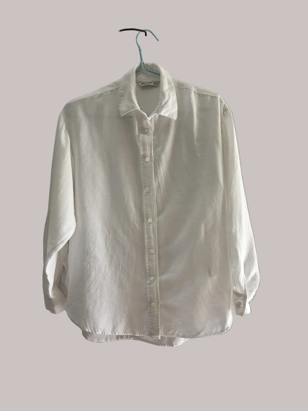 Vista completa de una blusa blanca Stradivarius de manga larga con botones frontales