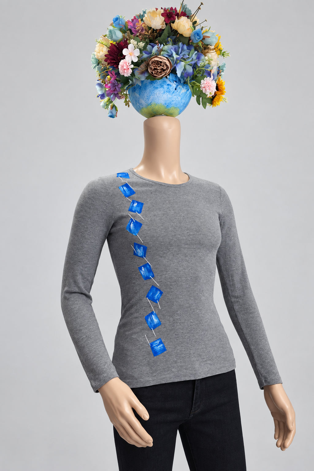 Detalle de camiseta gris pintada a mano sobre maniquí