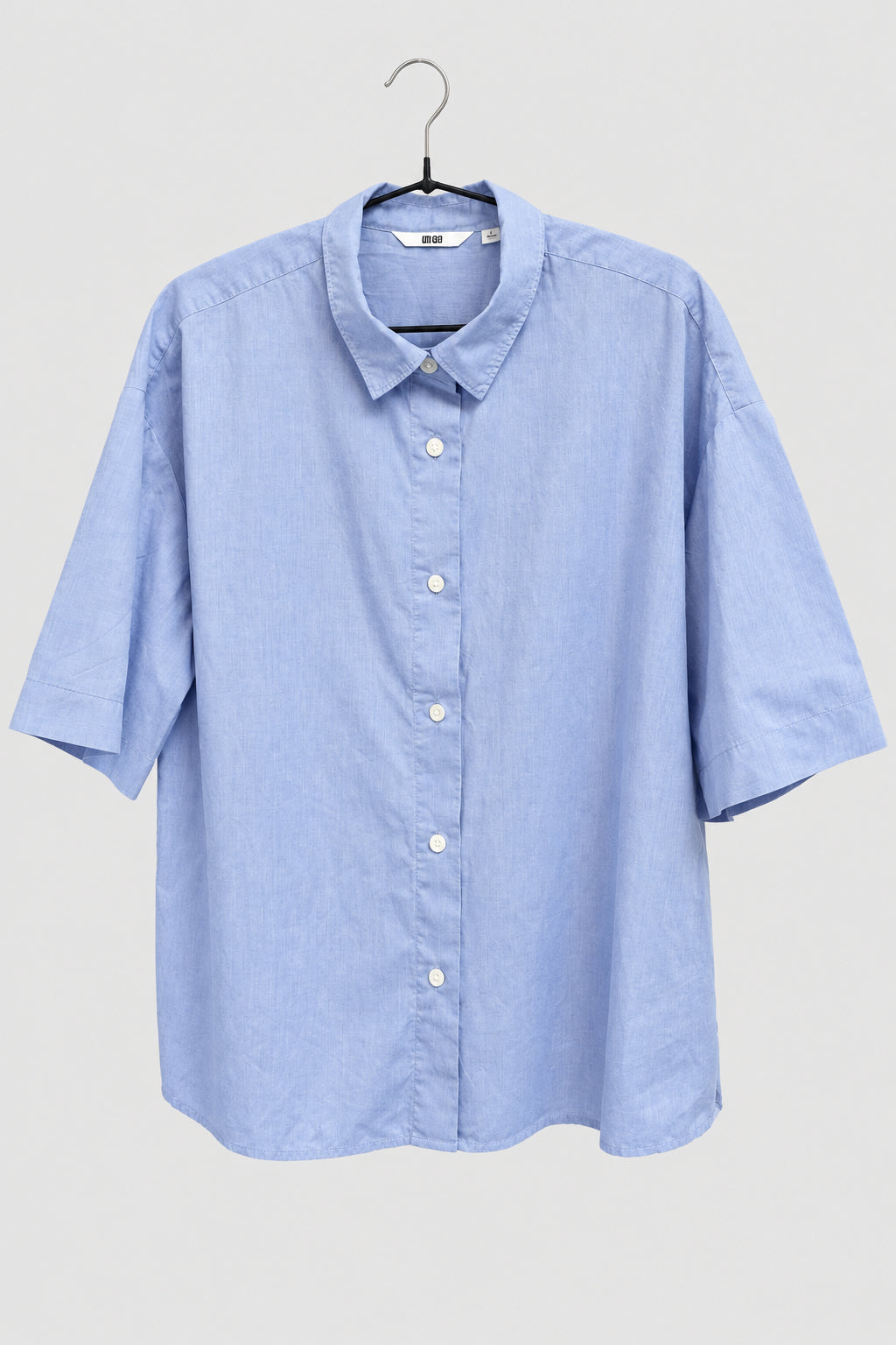 Blusa Uniqlo azul lisa con cuello y botones, vista frontal